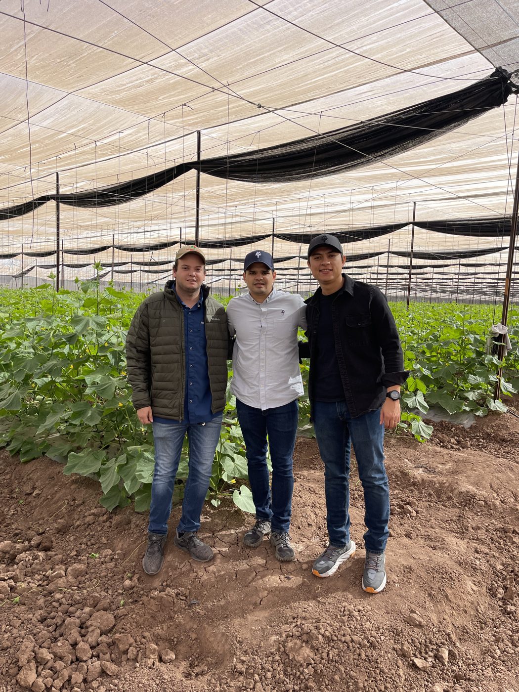 Yair con productores dentro de un invernadero
